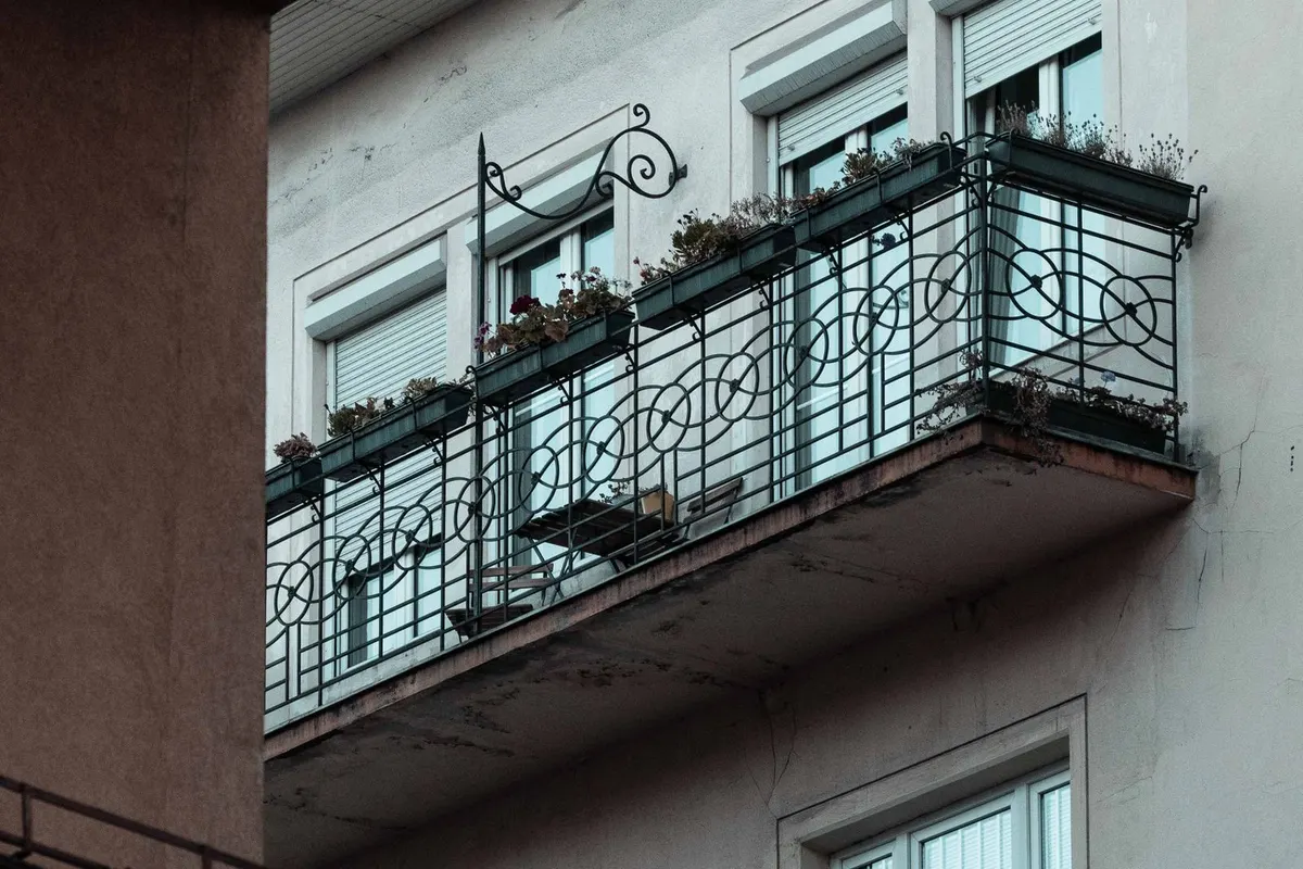 Älterer Balkon mit Metallgeländer an einer Fassade