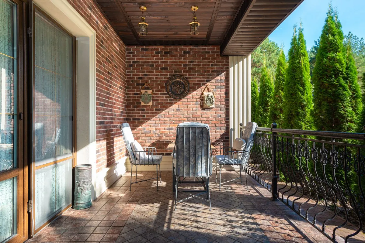 Überdachter Balkon mit gefliestem Boden und Sitzplatz