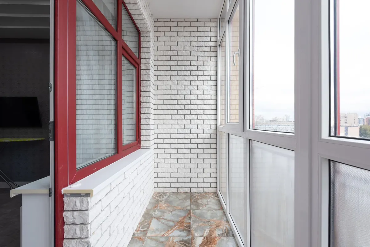 Verglaster Balkon mit hellem Steinboden