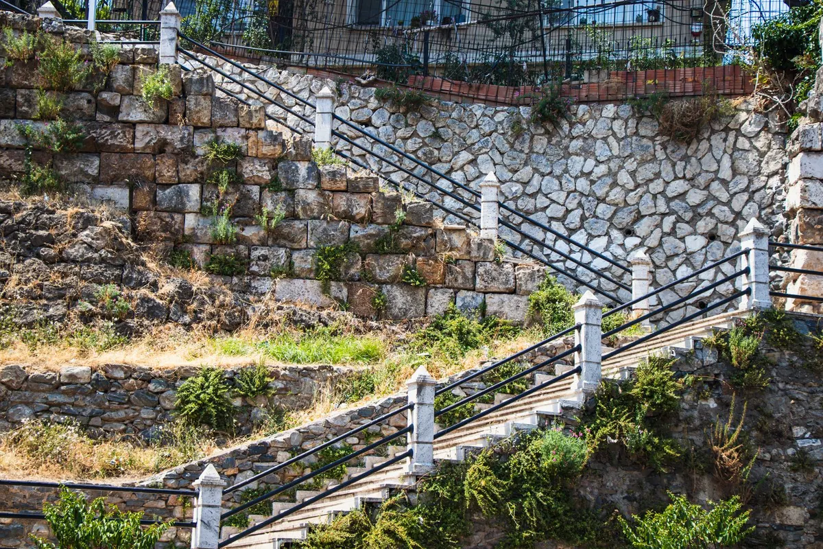 Steintreppe mit Blockstufen an einer Böschung mit Geländer