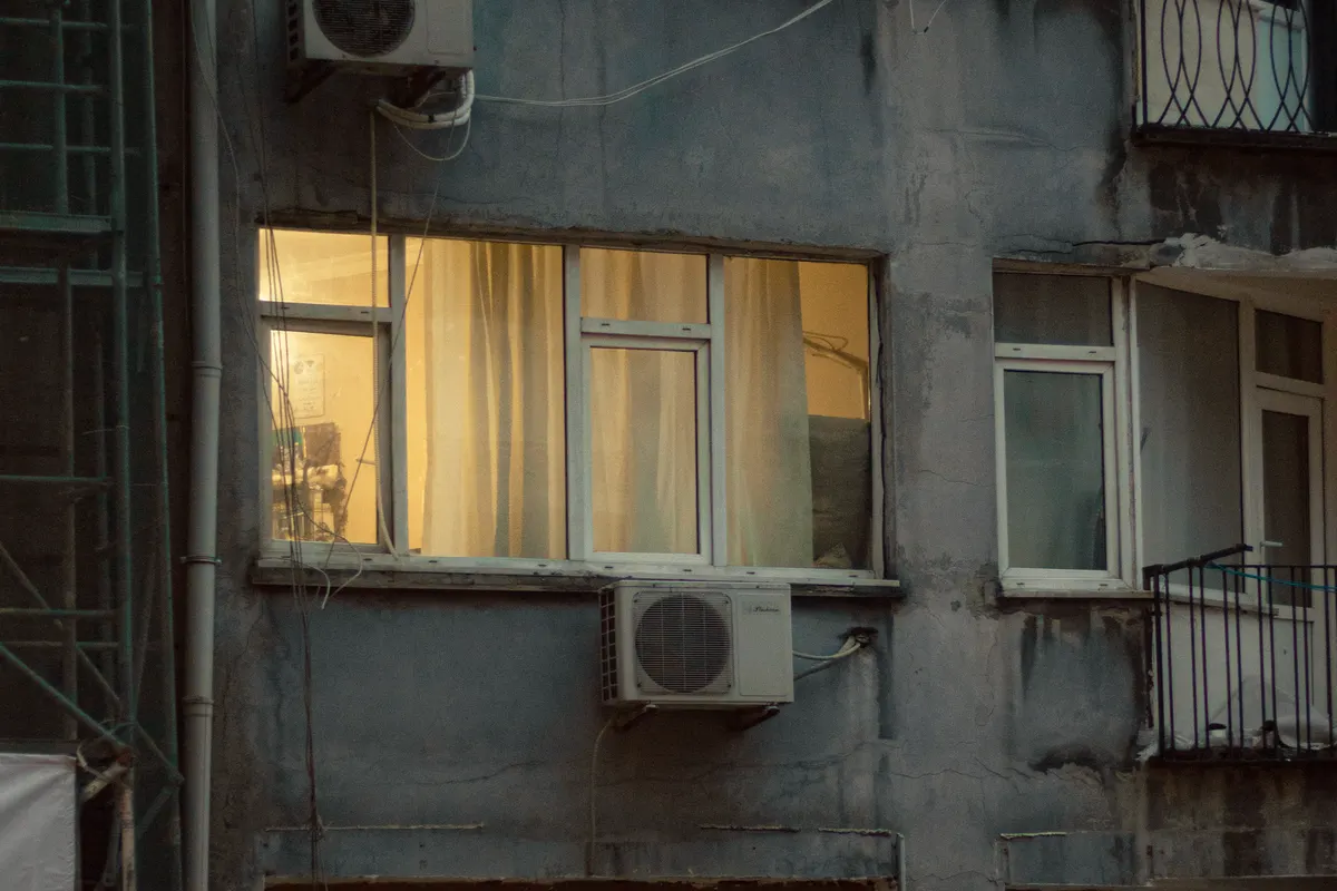 Beleuchtete Hausfassade mit warm erleuchteten Fenstern am Abend