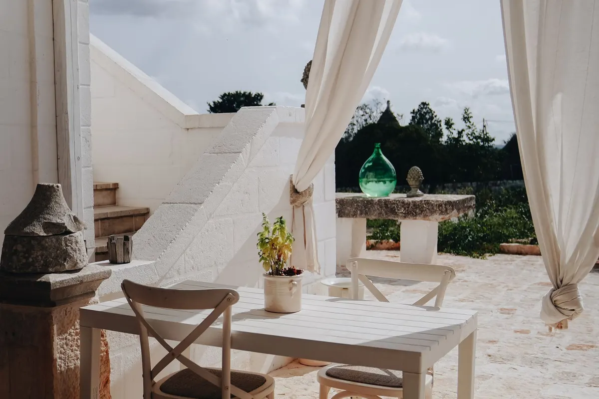 Moderne Terrasse mit heller Bestuhlung und Sichtschutz