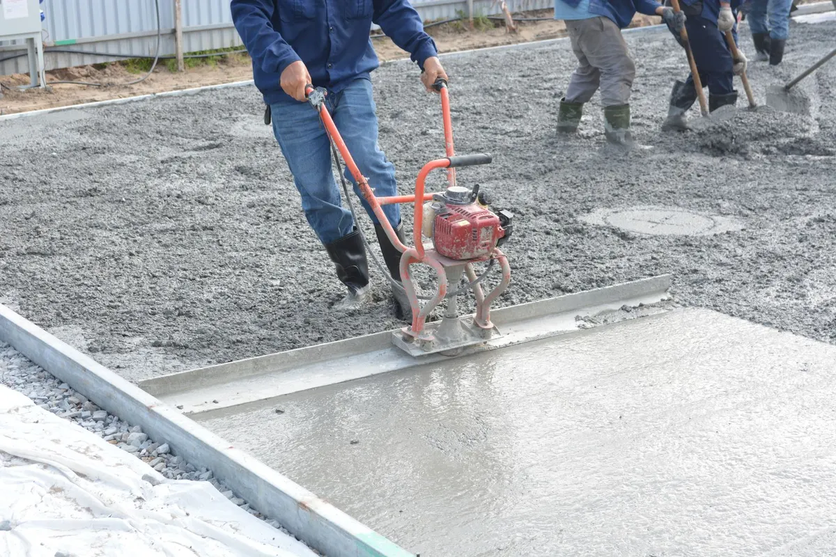Handwerker beim Abziehen einer Betonfläche