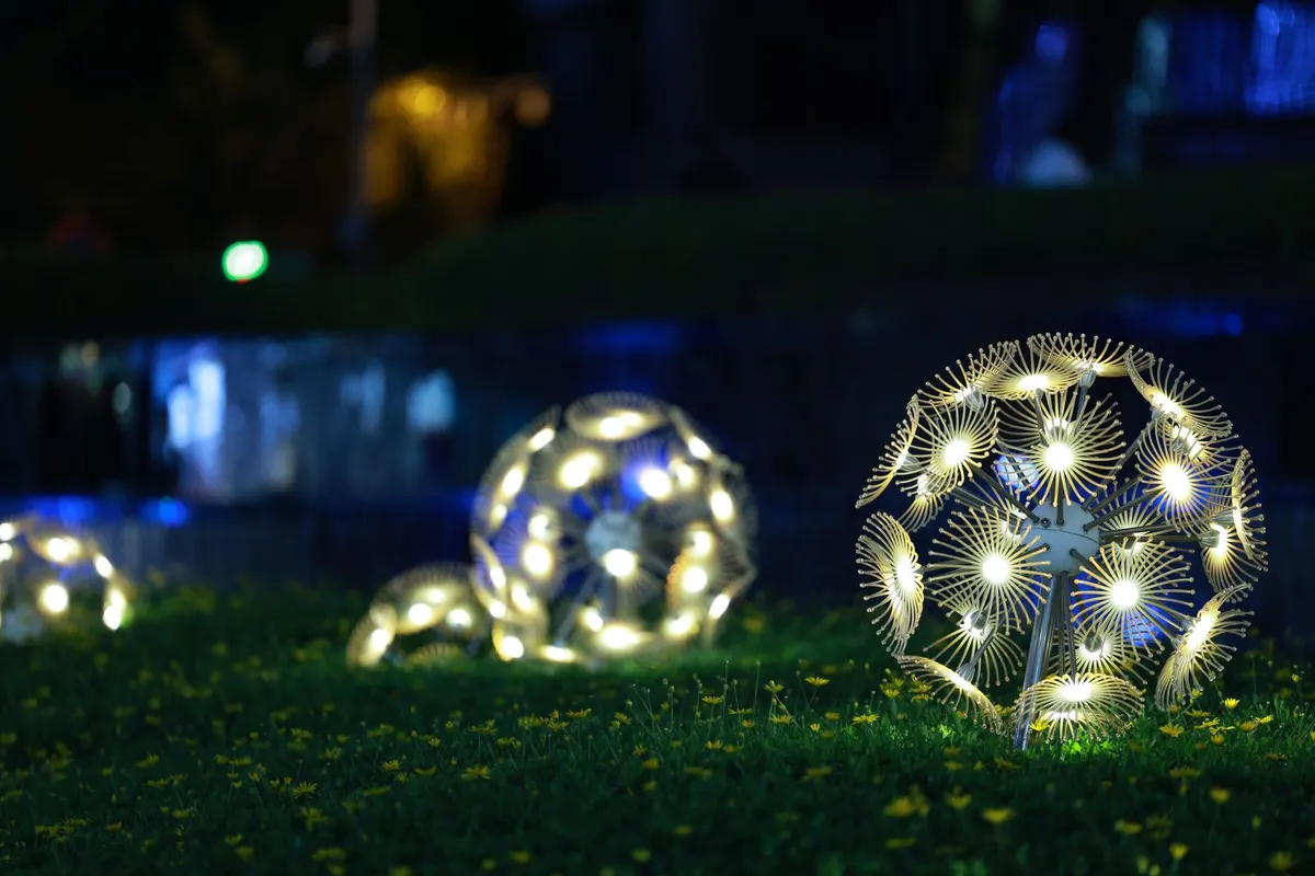 Beleuchtete Kugelleuchten in einem Garten bei Nacht