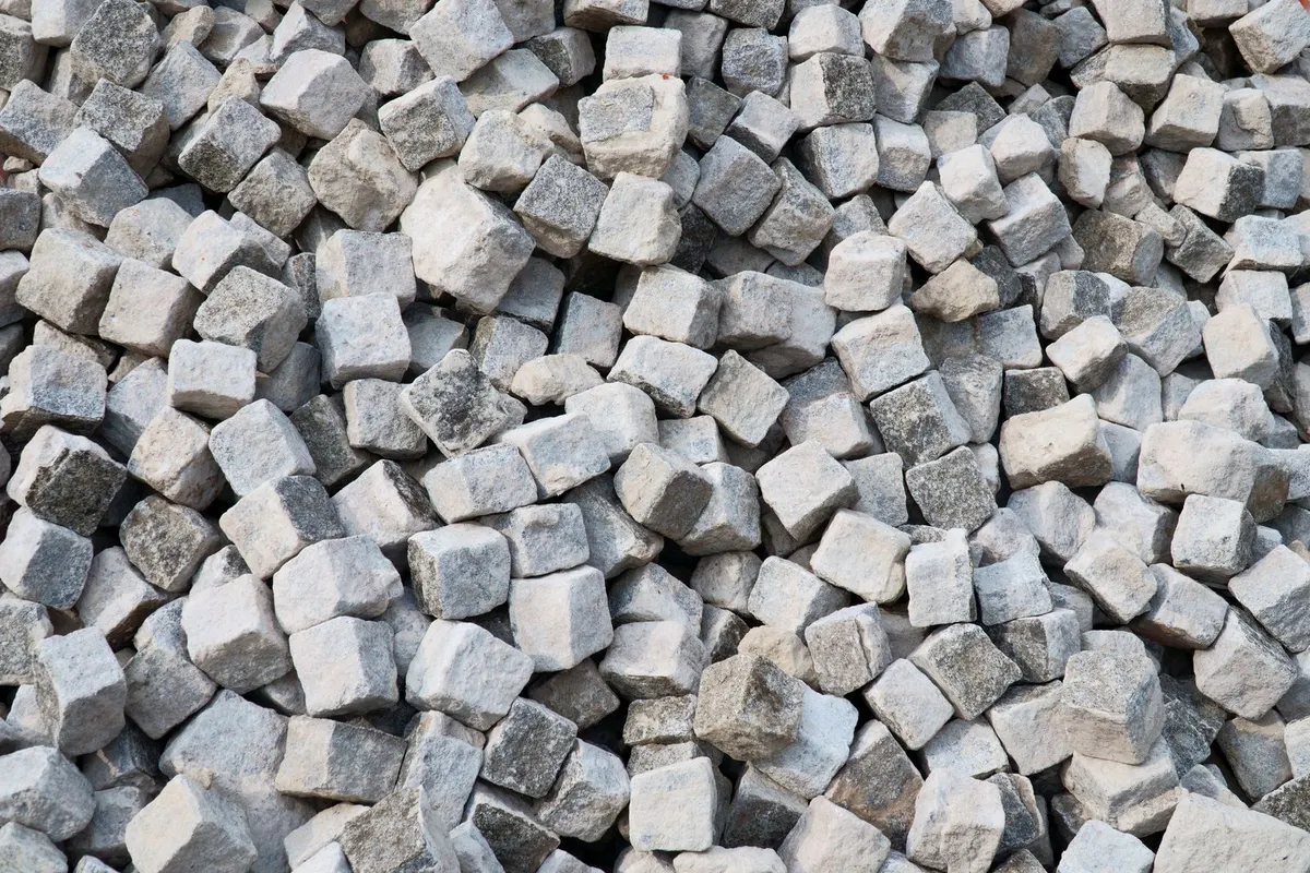 Haufen grauer Granit-Pflastersteine