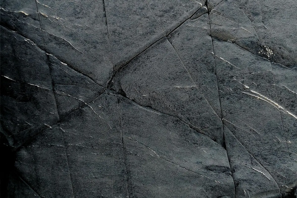 Rissige, dunkle Natursteinoberfläche