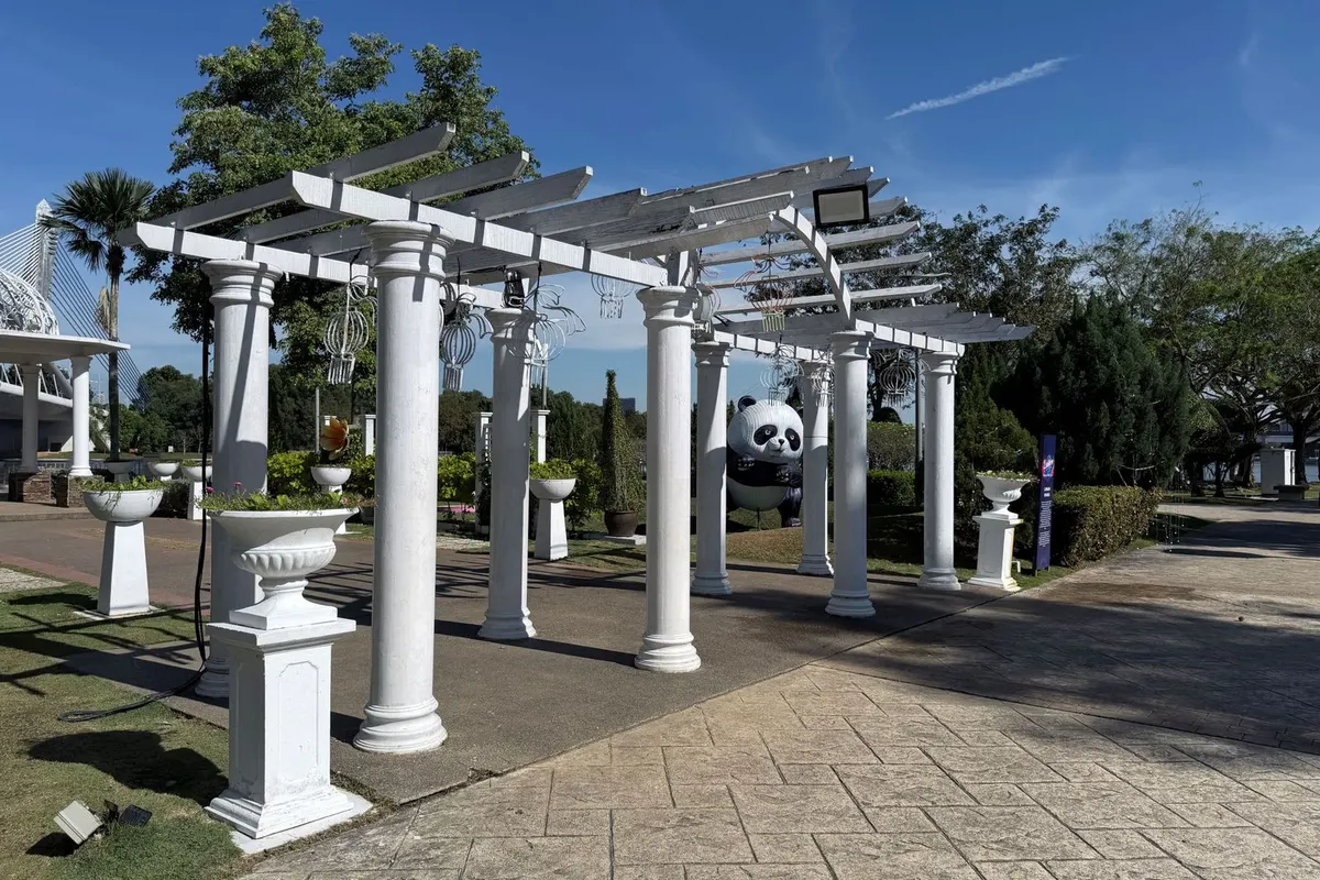 Weiße Pergola mit Säulen in einem gepflegten Garten