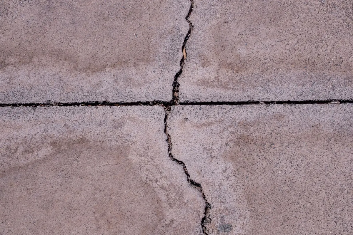 Rissige Betonplatte mit aufgeplatzter Fuge